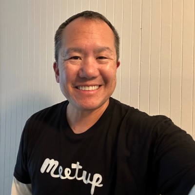 Dennis Shiao, founder of Attention Retention, smiles in a black t-shirt against a beige background. 