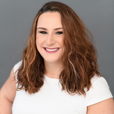 Jill Roberson, senior vice president of digital marketing at Velir, smiles in front of a grey background. 