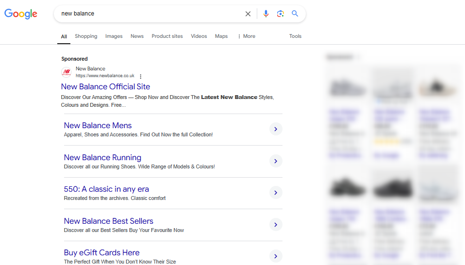 This is a screenshot of a Google search results page for the search query 'new balance'. The image shows a Google search ad at the top of the search results from the brand New Balance. There are 5 sitelinks showing below the ad and the Google Shopping listings on the right hand side are blurred out to highlight the Google search ad.